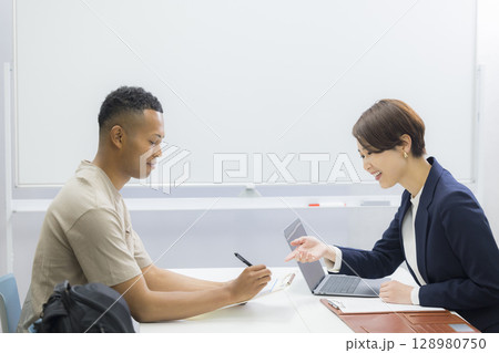 外国人の男性に説明をする女性 128980750