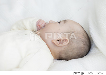 ベッドに寝転ぶ赤ちゃん ベッドに寝転ぶ赤ちゃん 128981287