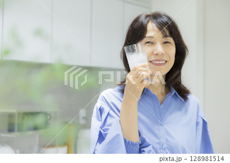 キッチンで水を飲む女性　 128981514