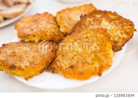 Potato pancakes with sour cream on white plate 128981694