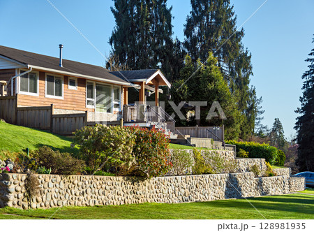 Family residential house on land terrace in sunset rays in British Columbia Family residential house on land terrace in sunset rays in British Columbia 128981935