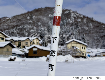 雪で覆われた福島県下郷町の民家と山の日常風景 128982060
