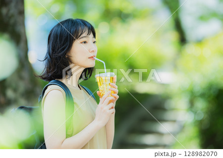 緑の中を歩く女性 128982070