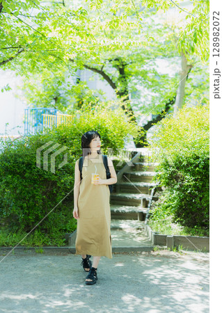 緑の中を歩く女性 128982072