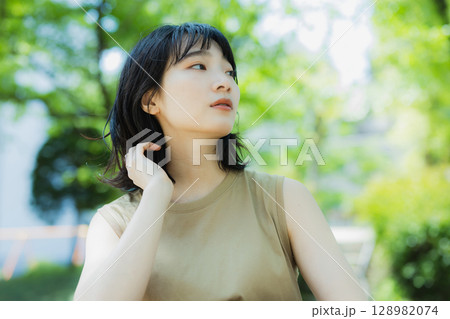 緑の中を歩く女性 128982074