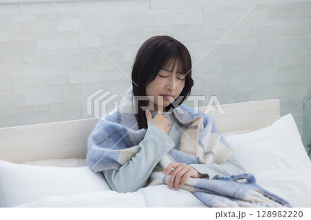 ベッドで疲れた表情の女性 128982220