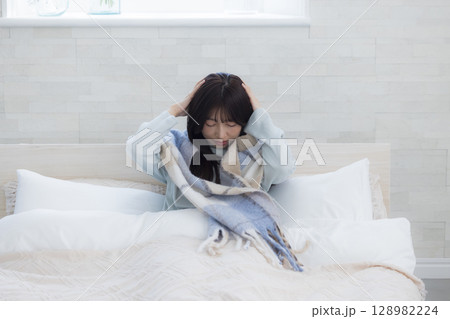 ベッドで疲れた表情の女性 ベッドで疲れた表情の女性 128982224
