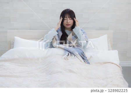 ベッドで疲れた表情の女性 128982225