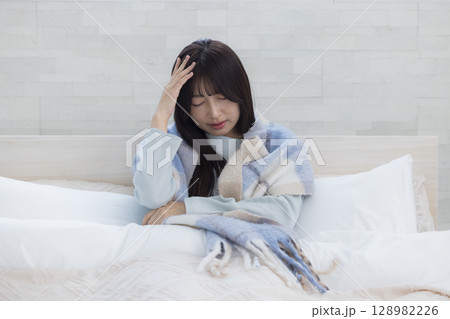 ベッドで疲れた表情の女性 ベッドで疲れた表情の女性 128982226