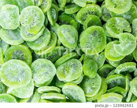 Vibrant dried kiwi slices close up background Vibrant dried kiwi slices close up background 128982681
