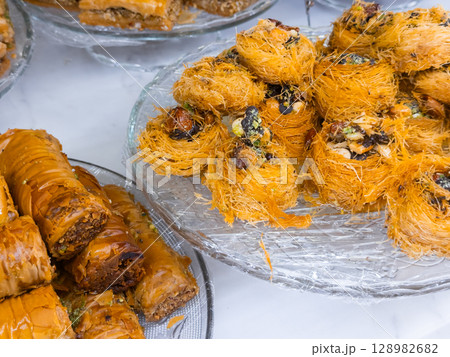 Assorted middle eastern pastries with baklava and kataifi on display Assorted middle eastern pastries with baklava and kataifi on display 128982682