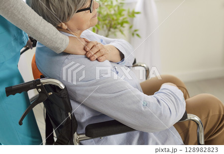 Compassionate nurse comforting elderly woman in wheelchair, showing care, support and understanding. Compassionate nurse comforting elderly woman in wheelchair, showing care, support and understanding. 128982823