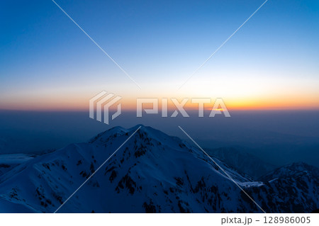 立山の奥大日岳に沈む夕日(剱御前からのブルーアワーの景色) 残雪期の北アルプス立山・別山登山 立山の奥大日岳に沈む夕日(剱御前からのブルーアワーの景色) 残雪期の北アルプス立山・別山登山 128986005