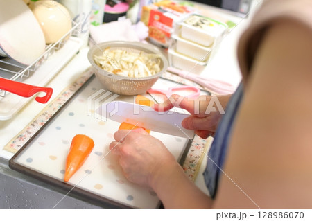 ニンジンを切る女性のイメージ 128986070