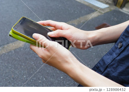 スマホを触る若い男性の手指　20代学生2 128986432