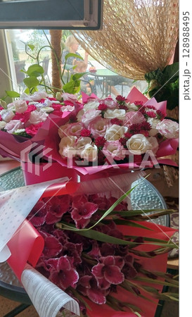 Two Bouquets of Pink and White Roses with Purple Flowers on a Glass Table Indoors 128988495