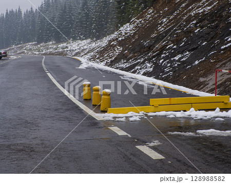 Yellow road closed barrier blocking dangerous snow ice weather covered road Yellow road closed barrier blocking dangerous snow ice weather covered road 128988582