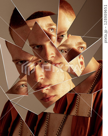 Bold artwork of young man face reflected in shattered mirror pieces with intense expression 128989651