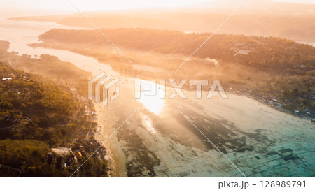 Nusa Lembongan and Nusa Ceningan bridge. Drone view of a bridge connecting two islands over a narrow ocean channel. 128989791