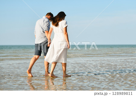 A couple walking on the ocean 128989811