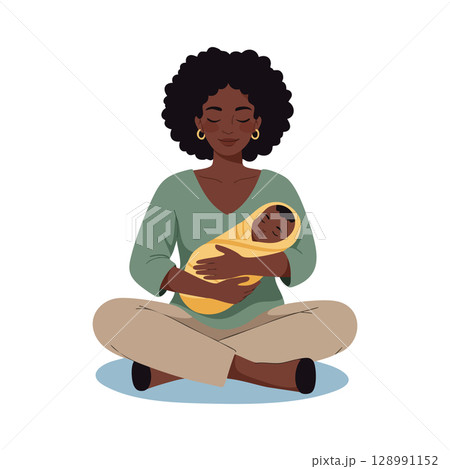 African American mother holding baby wrapped in yellow blanket sitting cross legged calm moment 128991152