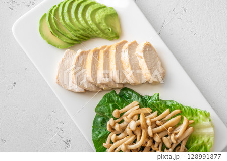 Avocado, mushrooms, and chicken presented as fresh minimalist healthy lifestyle plate 128991877
