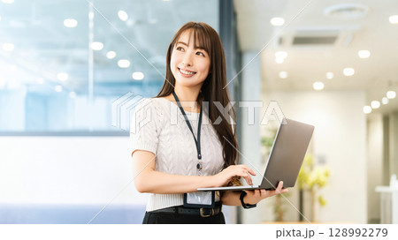 オフィスでパソコンを使う笑顔の女性 128992279