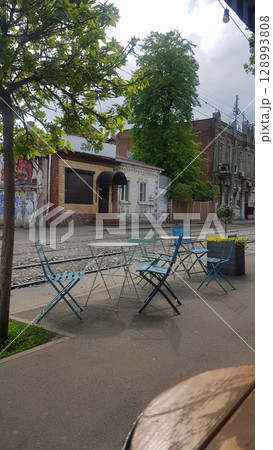 A charming street-side outdoor cafe area features light blue and white A charming street-side outdoor cafe area features light blue and white 128993808