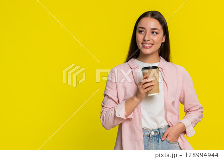 Woman holding takeaway coffee cup sipping drink, enjoying aroma satisfied relaxed happy expression 128994944