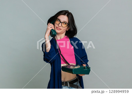 Woman emotionally talking on retro wired phone explaining something actively expressive reaction Woman emotionally talking on retro wired phone explaining something actively expressive reaction 128994959