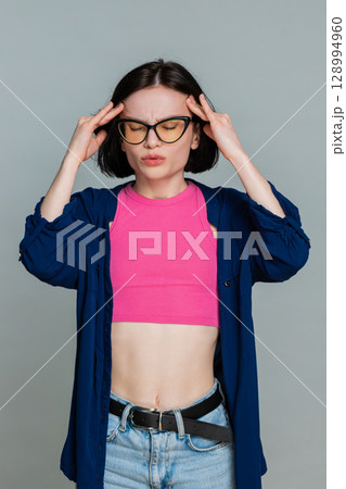 Woman holding head with hands showing pain discomfort headache emotional stress facial reaction Woman holding head with hands showing pain discomfort headache emotional stress facial reaction 128994960