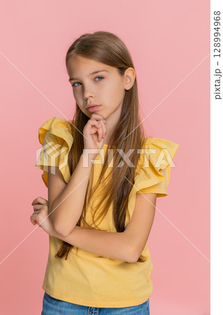 Child girl kid thoughtfully touching chin thinking hard about difficult question solving problem Child girl kid thoughtfully touching chin thinking hard about difficult question solving problem 128994968