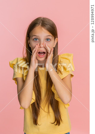 Child girl kid screaming with hands around mouth pretending to use loudspeaker call someone loudly 128994971