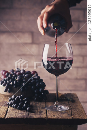 Pouring red wine Pouring red wine 128995019