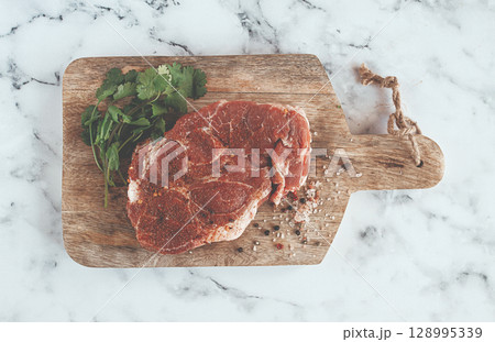 raw pork steak , pork neck, on a chopping board, marble table, top view, with spices and coriander, no people, raw pork steak , pork neck, on a chopping board, marble table, top view, with spices and coriander, no people, 128995339