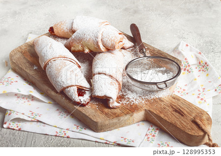 bagels with filling, sweet pastries, sprinkled with powdered sugar, on a wooden board, dessert, breakfast, bagels with filling, sweet pastries, sprinkled with powdered sugar, on a wooden board, dessert, breakfast, 128995353