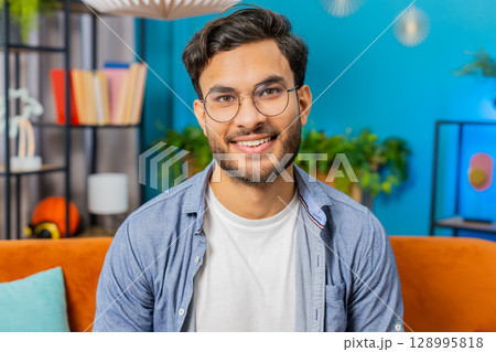 Happy Indian man smiling friendly, glad expression, feel satisfied concept good news celebrate win 128995818