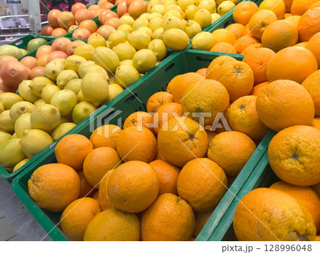 Colorful citrus display at a bustling market during the afternoon 128996048