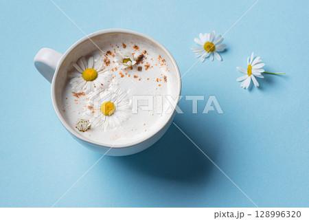 Chamomile moon milk on blue background Chamomile moon milk on blue background 128996320