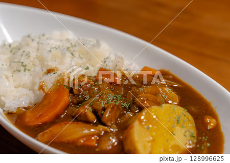 じゃがいもやにんじんが入った家庭的なカレーライスの夕食 128996625