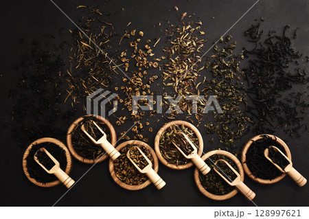Colorful mix of tea varieties: red and black, green and white, oolong and herbal, selective focus, shallow DOF 128997621