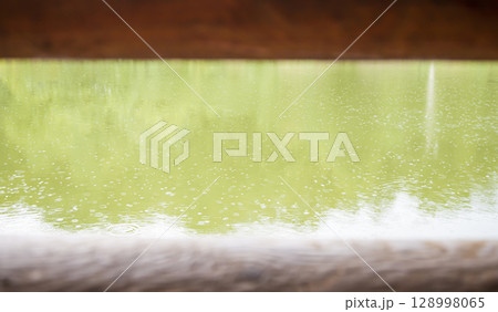 Rain drops on the water, through two wooden beams. An autumnal concept, and an empty space for your advertising. 128998065