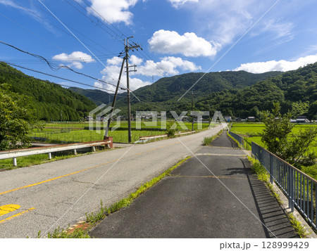 夏の田園を通る道路の風景 夏の田園を通る道路の風景 128999429