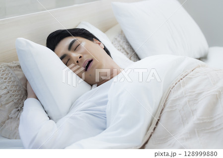 ベッドで眠る若い男性 ベッドで眠る若い男性 128999880