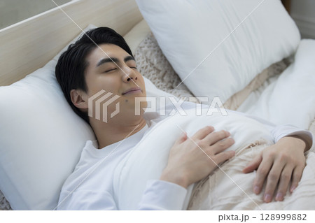 ベッドで眠る若い男性 ベッドで眠る若い男性 128999882