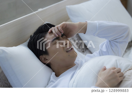 ベッドで眠る若い男性 ベッドで眠る若い男性 128999883