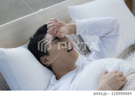 ベッドで眠る若い男性 ベッドで眠る若い男性 128999884