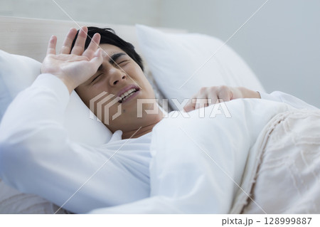 ベッドで眠る若い男性 ベッドで眠る若い男性 128999887