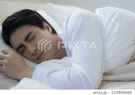 ベッドで眠る若い男性 ベッドで眠る若い男性 128999888