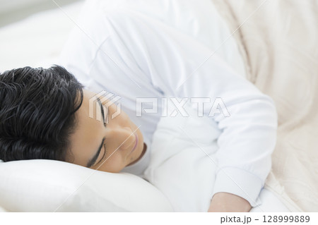 ベッドで眠る若い男性 ベッドで眠る若い男性 128999889